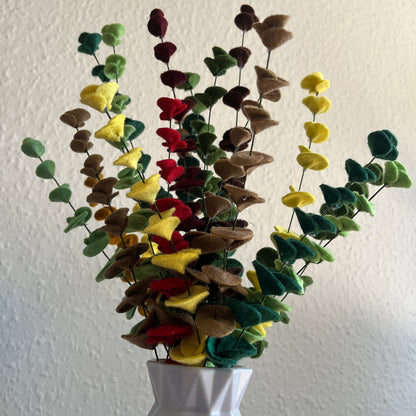 Colorful artificial eucalyptus plant with green, yellow, and red leaves